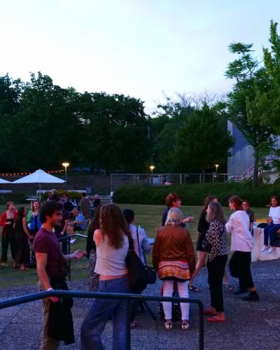 Teilnehmende auf dem Veranstaltungsgelände während des Sommerfests 2026 im Philharmonischen Garten Berlin in den Abendstunden. 