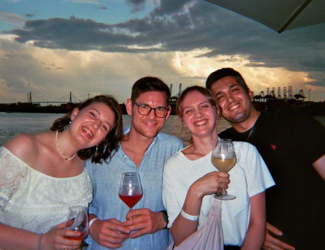 Teilnehmende beim Sommerfest 2026 in Hamburg während der Abendstunden mit Blick auf Elbe und Hafen. 