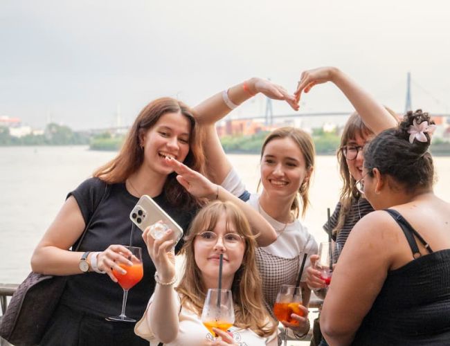 Teilnehmende auf der Terrasse an der Elbe beim Sommerfest 2026 in Hamburg. 