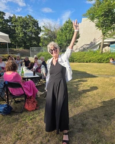 Teilnehmende verbringen gemeinsame Zeit auf der Festwiese beim Sommerfest 2026 im Philharmonischen Garten Berlin. 